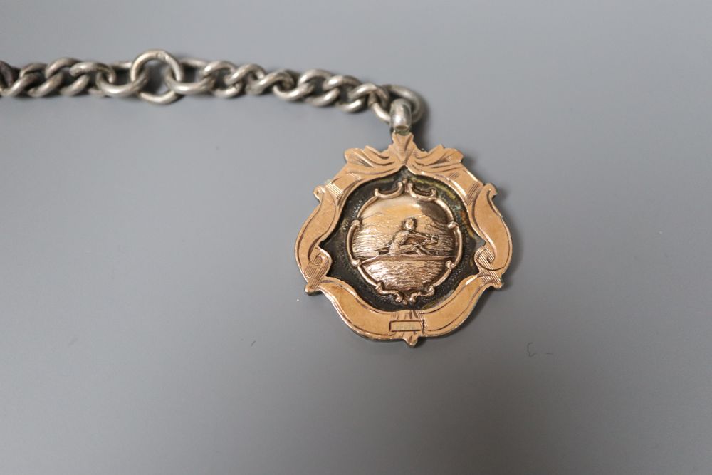 An Indian white metal belt and two alberts including silver and a silver and yellow metal medallion.